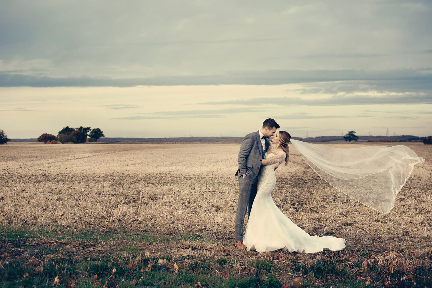A bride and groom make use of the countryside surrounding Bassmead Manor Barns to capture stunning wedding photographs