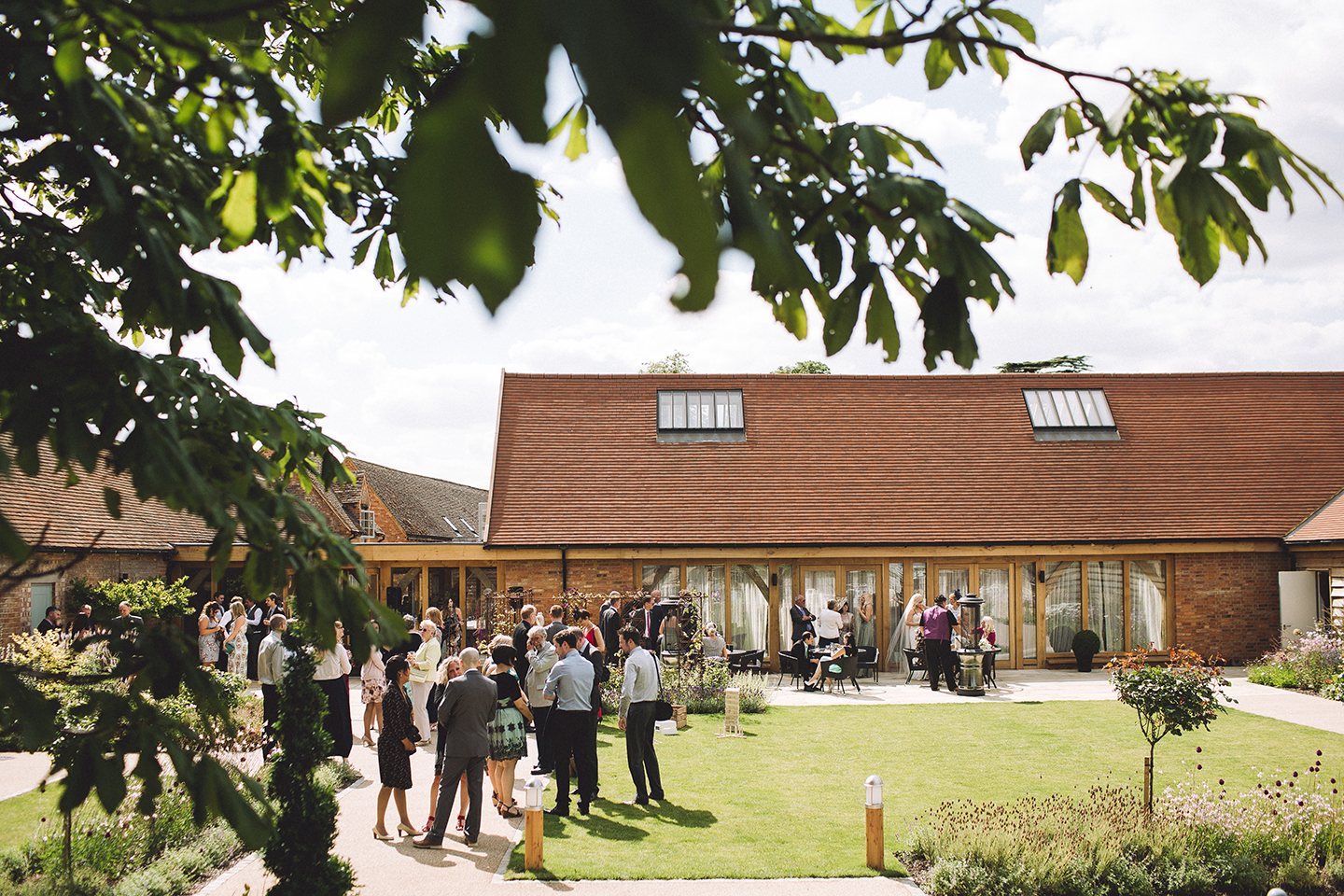 Guests enjoy a wedding drinks reception after a beautiful barn wedding at Bassmead Manor Barns