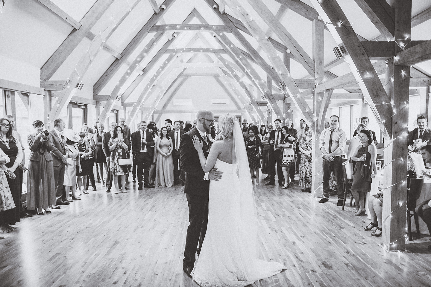The newlyweds enjoy their first dance in the Bridge Barn at this Cambridgeshire barn wedding venue