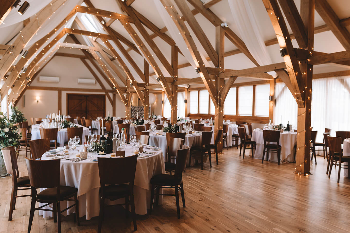 The Bridge Barn at Bassmead Manor Barns is adorned in fairy lights for a winter wedding