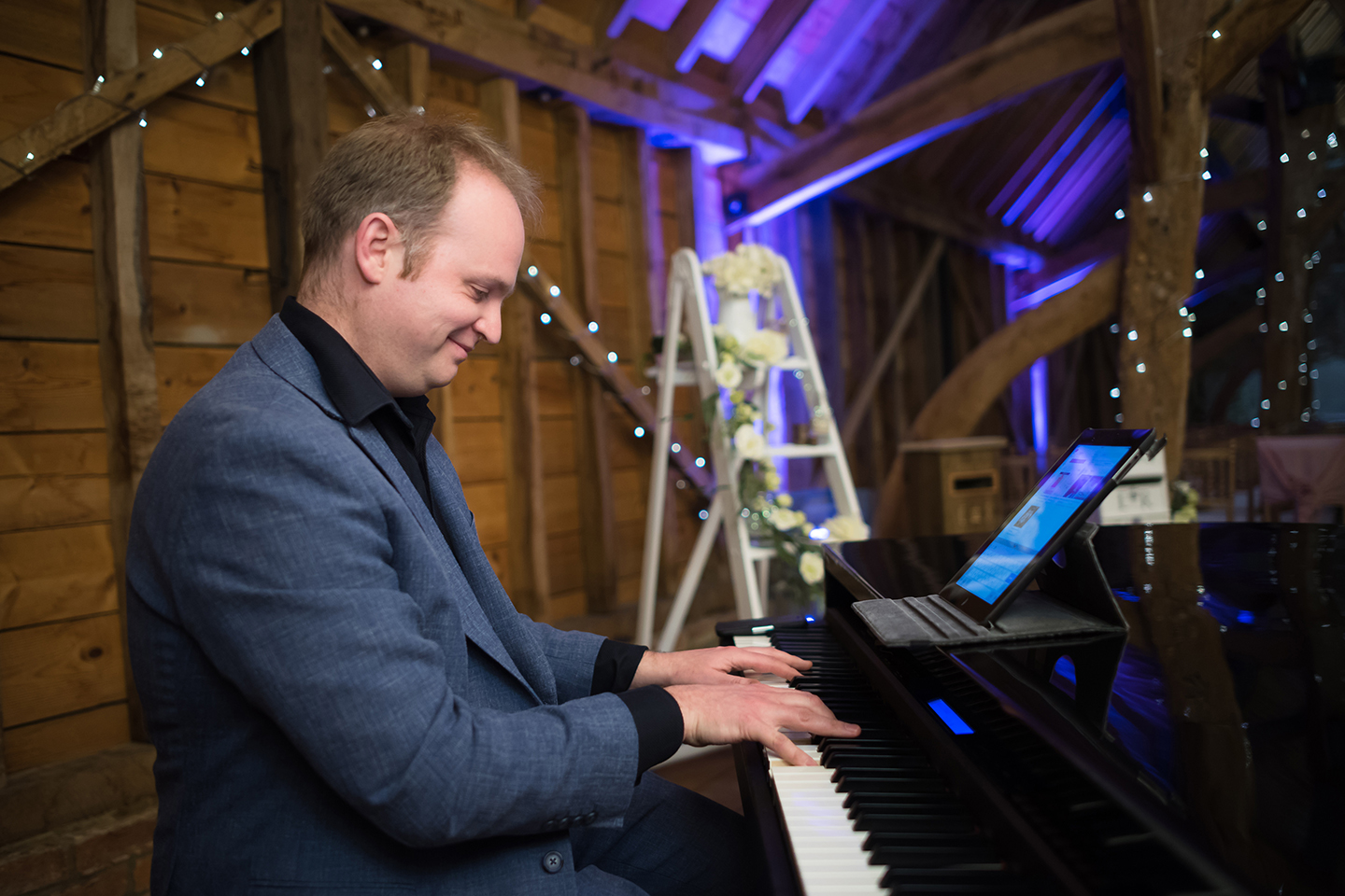 A wedding pianist plays for guests during a tasting event at Bassmead Manor Barns