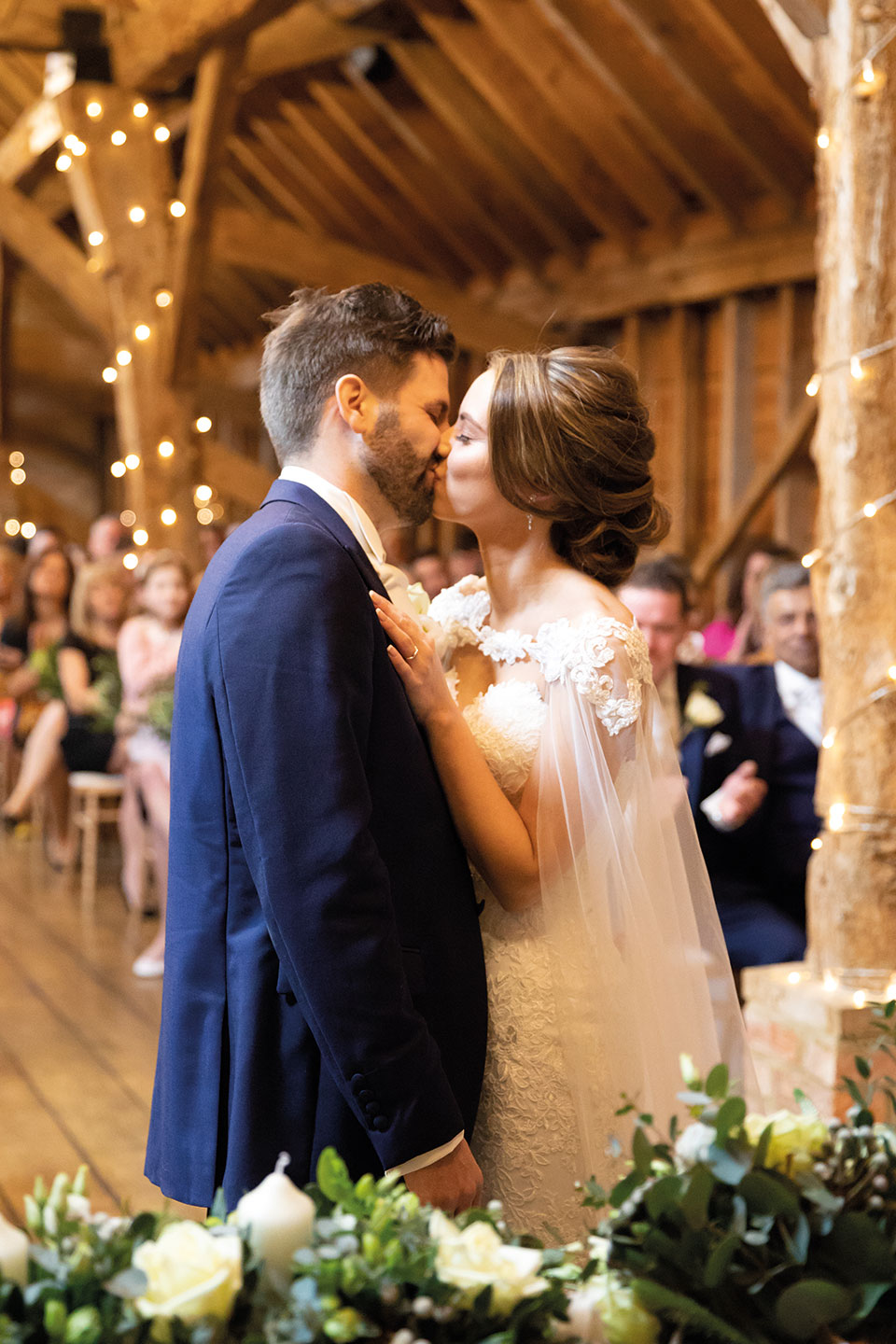 The newlyweds share a kiss in the Rickety Barn at Bassmead Manor Barns during their wedding ceremony